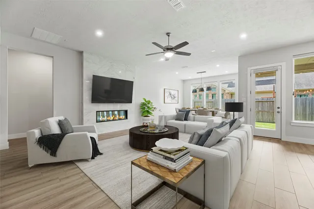 a living room with furniture a flat screen tv and a large window
