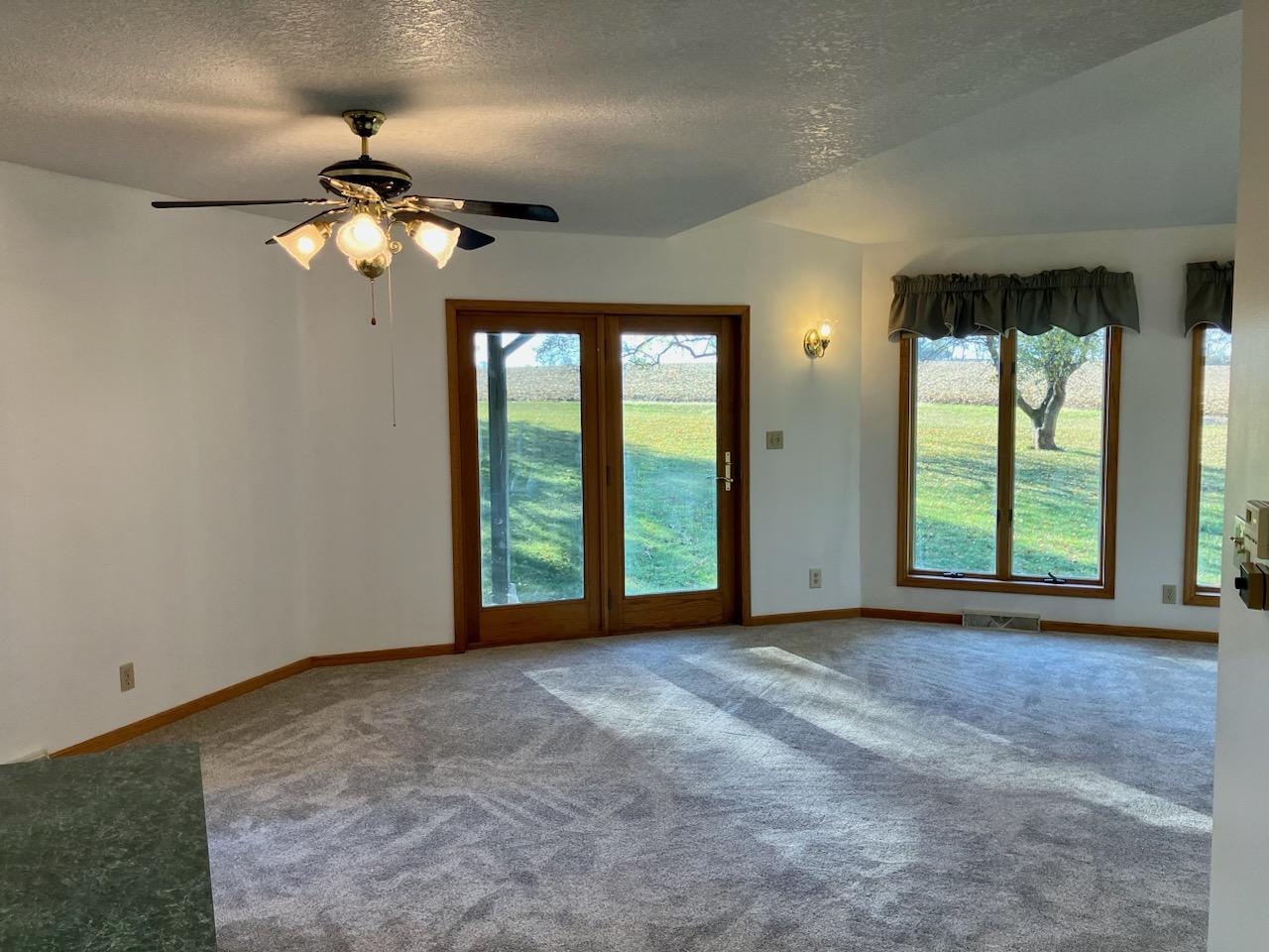 7561 West Judson Road Polo, IL 61064 - Photo 8 of 44 a view of an empty room with window and chandelier fan