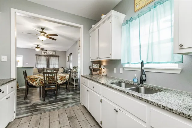 a kitchen with stainless steel appliances granite countertop a sink a stove and a dining table view