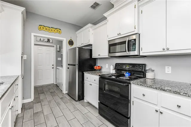 a kitchen with stainless steel appliances granite countertop a refrigerator and a stove top oven