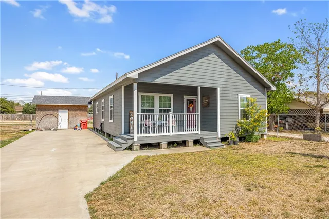 a view of a house with large windows and plants