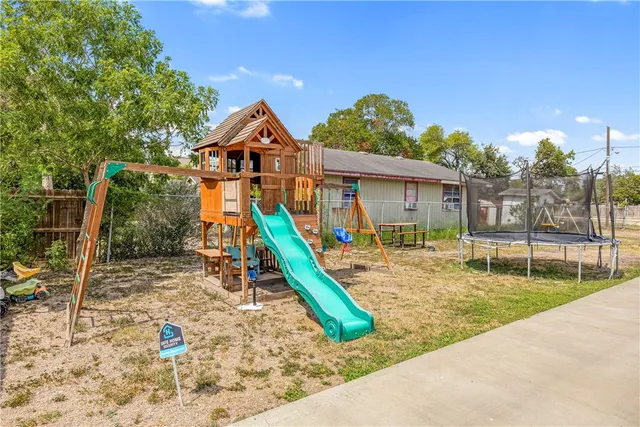 a view of a house with a yard and wooden fence