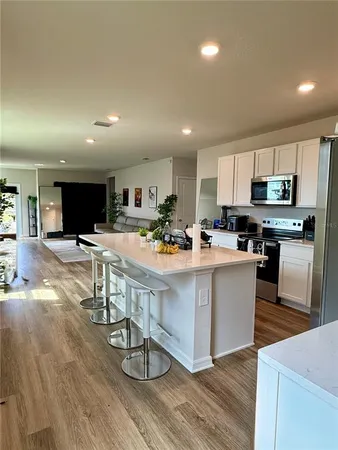 a view of kitchen with stainless steel appliances refrigerator stove microwave and cabinets