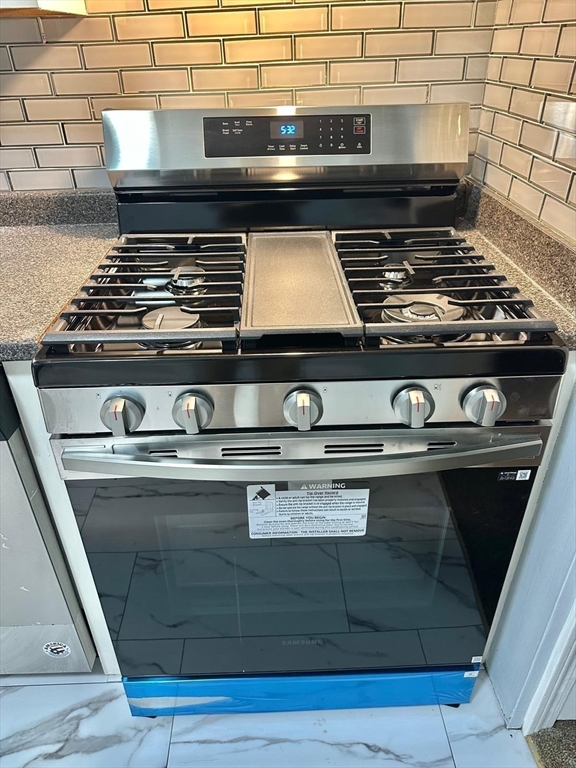 363 Hildreth Street, Unit 11 Lowell, MA 01850 - Photo 6 of 17 a stove top oven sitting inside of a kitchen