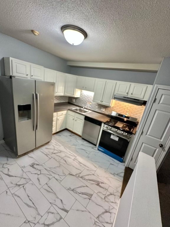 363 Hildreth Street, Unit 11 Lowell, MA 01850 - Photo 8 of 17 a kitchen with stainless steel appliances granite countertop a refrigerator and a stove