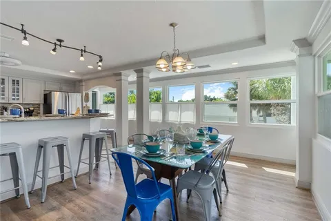 a dining room with furniture a chandelier and wooden floor