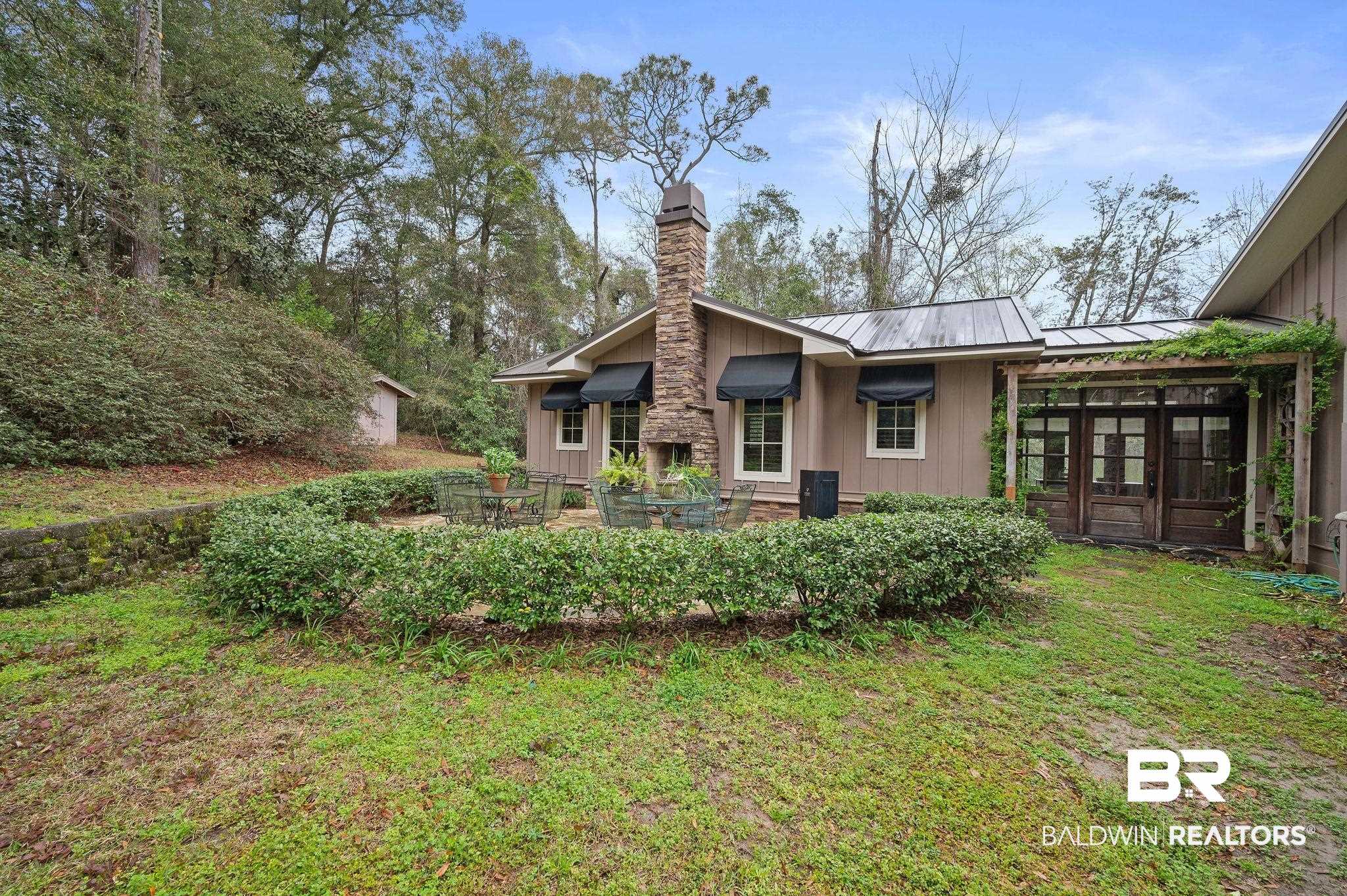 7850 Yorkhaven Road Mobile, AL 36695 - Photo 4 of 57 Rear view of property featuring a standing seam roof, a yard, board and batten siding, metal roof, and a chimney
