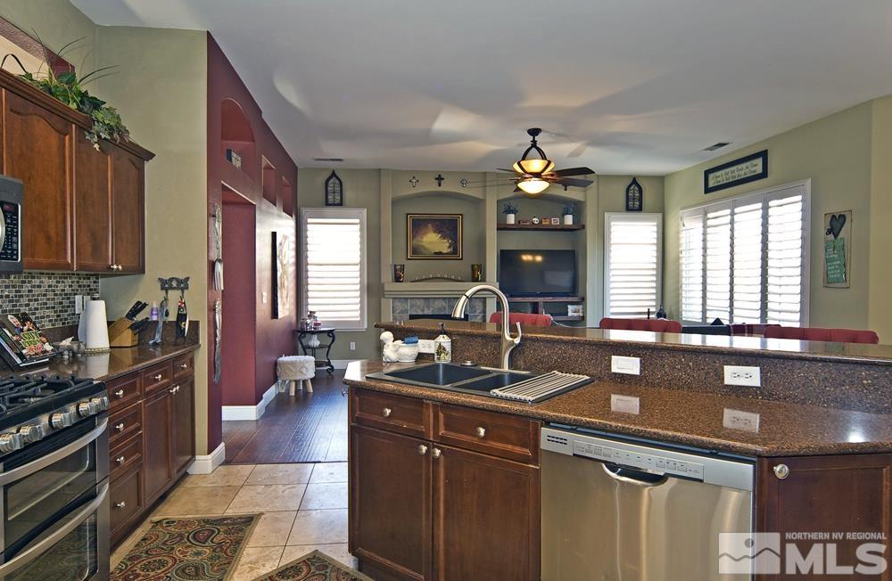 1795 Arrow Wood Court Reno, NV 89521 - Photo 12 of 40 a kitchen with granite countertop a sink dishwasher stove and cabinets