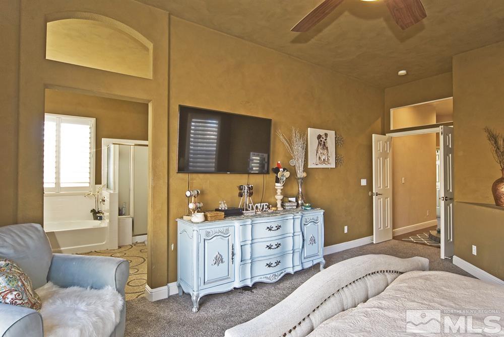 1795 Arrow Wood Court Reno, NV 89521 - Photo 21 of 40 a spacious bedroom with a bed a dresser and a chandelier
