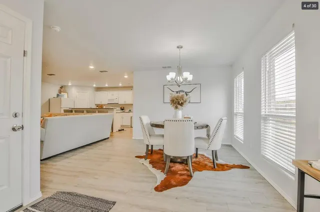 a view of a dining room with furniture a chandelier and wooden floor
