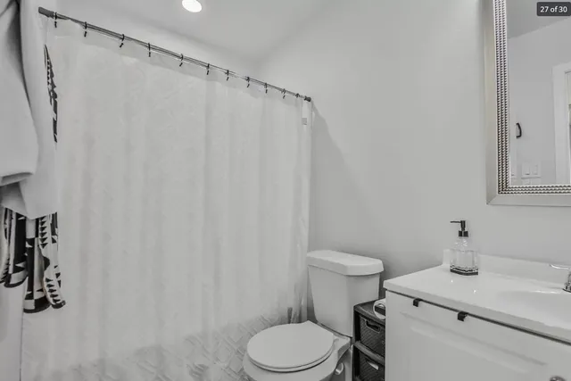 a bathroom with a sink a toilet and shower curtain