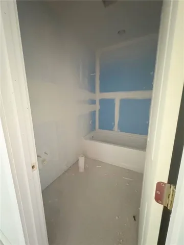 a view of an empty room with a window and a dresser