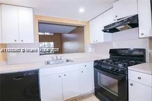 a kitchen with stainless steel appliances a stove a sink and a microwave