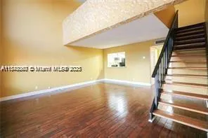 a view of a room with wooden floor and windows