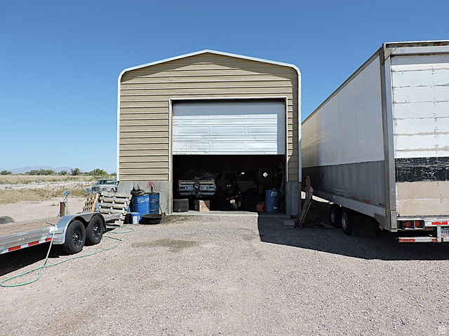 915 North 5000 W Road Hinckley, UT 84635 - Photo 26 of 27 Metal-sided garage structure with a large overhead door