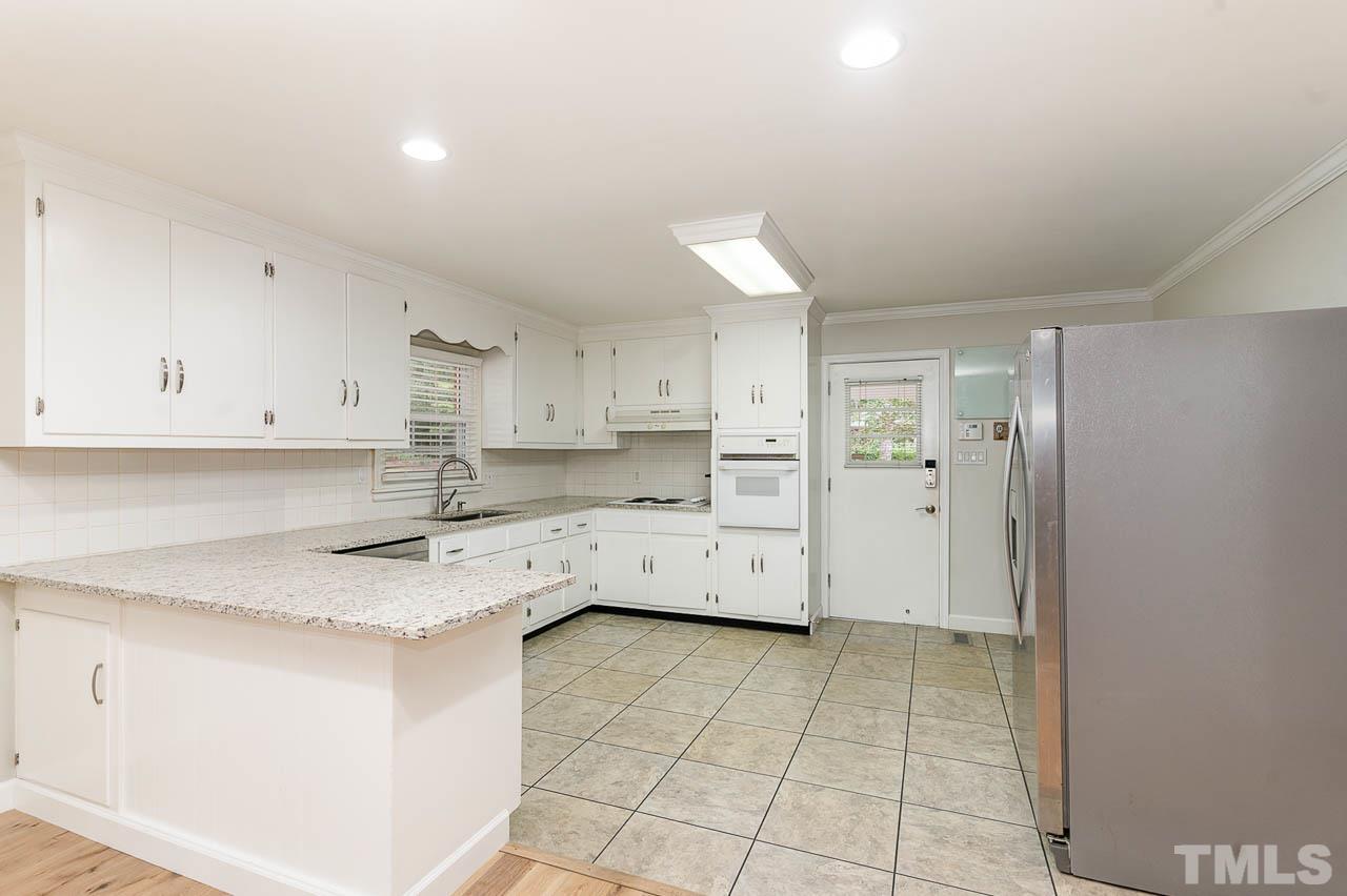 821 Snow Hill Road Durham, NC 27712 - Photo 6 of 15 a kitchen with a sink a stove and cabinets