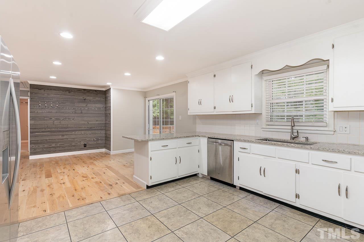 821 Snow Hill Road Durham, NC 27712 - Photo 7 of 15 a kitchen with granite countertop white cabinets sink and stainless steel appliances