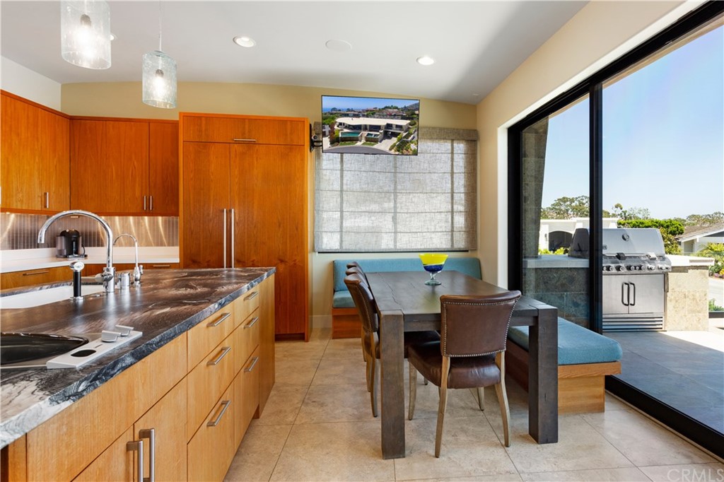 50 Monarch Bay Drive Dana Point, CA 92629 - Photo 10 of 34 a kitchen with kitchen island granite countertop wooden cabinets a dining table and chairs