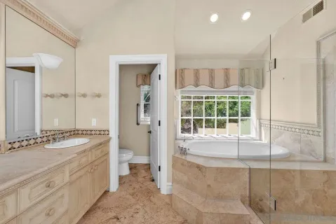 a spacious bathroom with a granite countertop sink and a mirror