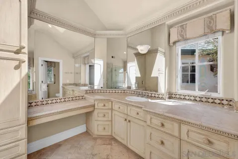 a spacious bathroom with a granite countertop sink and a mirror