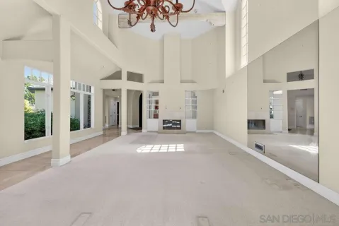 a view of a hallway with a chandelier and mirror