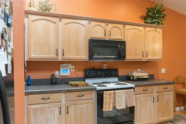 a kitchen with stainless steel appliances granite countertop a stove microwave and cabinets