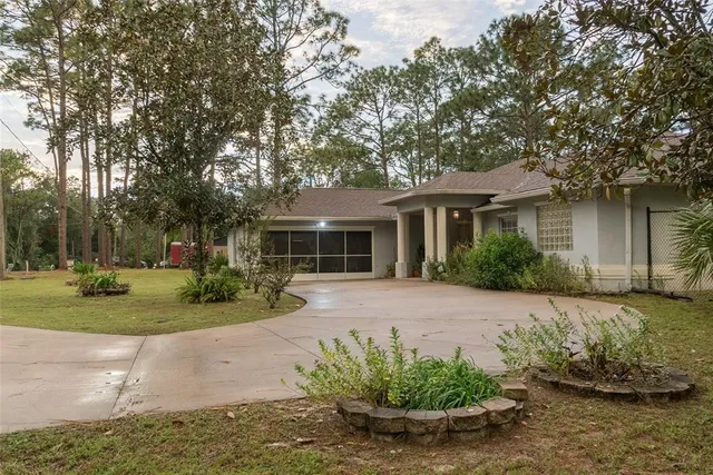 a front view of a house with a yard and potted plants