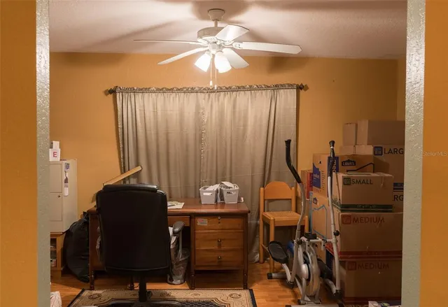 a view of a workspace with furniture and a window