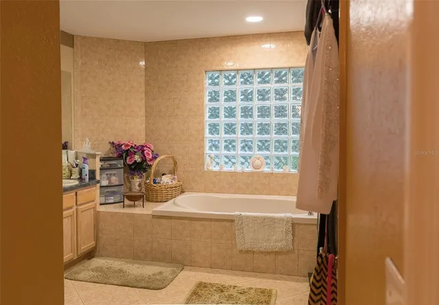a bathroom with a tub sink and mirror