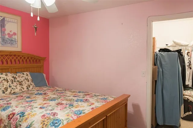 a bedroom with a bed and a flat tv screen on dresser