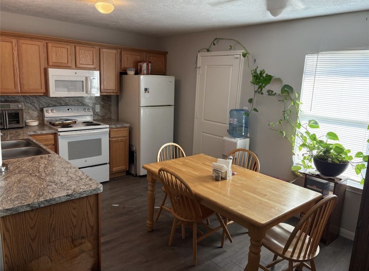 3940 Frontier Road Willis, TX 77378 - Photo 13 of 13 a kitchen with a table chairs refrigerator and microwave