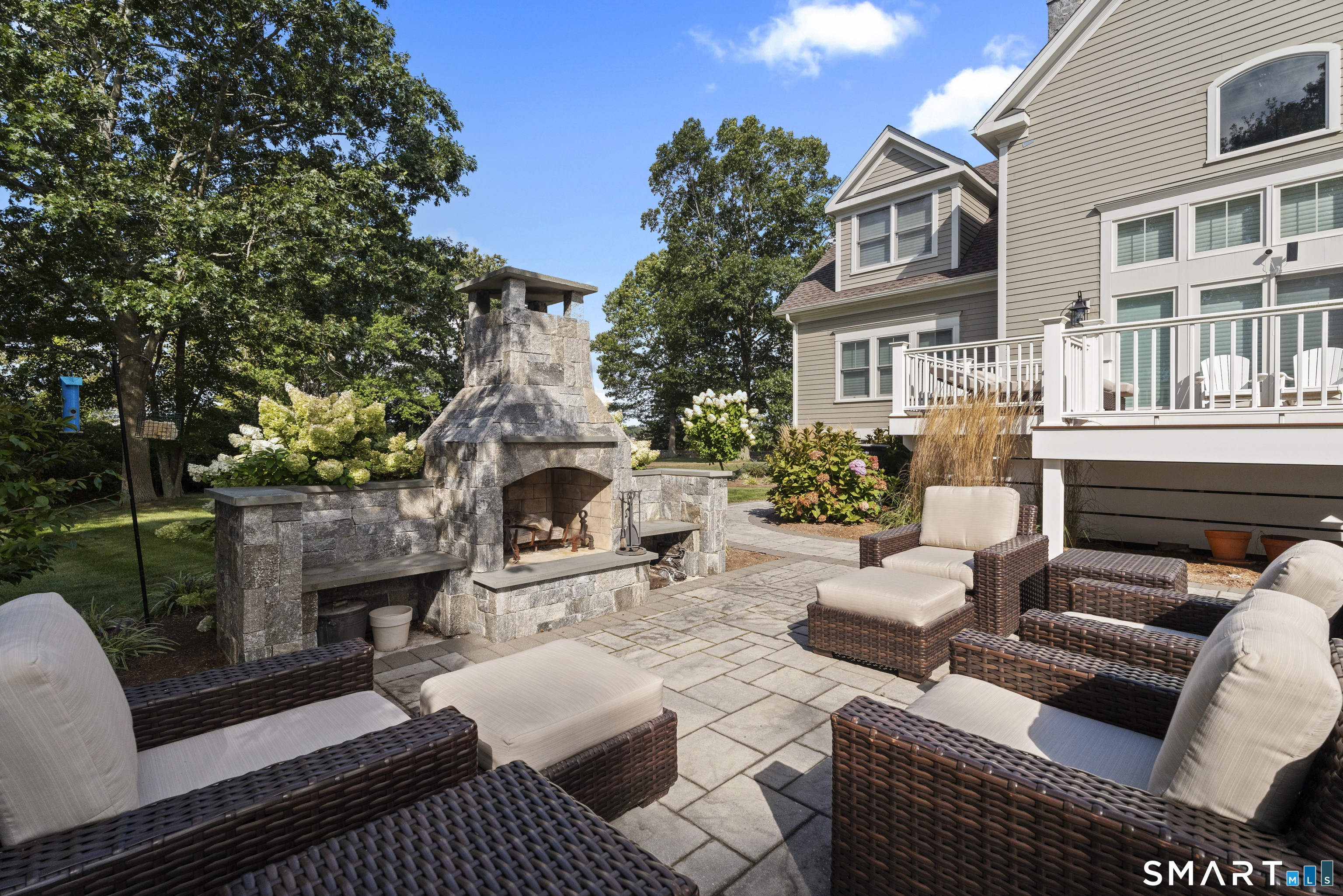 101 Garnet Park Road Madison, CT 06443 - Photo 37 of 40 a view of a patio with couches table and chairs with potted plants and a fireplace