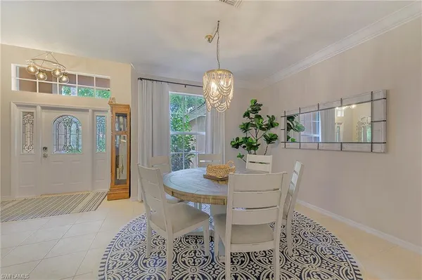 a dining room with furniture potted plants and wooden floor