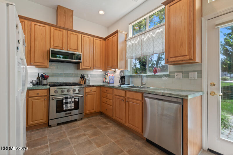403 Sierra Leaf Circle Reno, NV 89511 - Photo 9 of 25 a kitchen with stainless steel appliances granite countertop a stove sink and cabinets