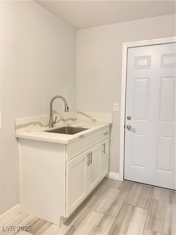 9637 Greensburg Avenue Las Vegas, NV 89178 - Photo 14 of 33 Laundry room featuring wood finish floors, a sink, and baseboards