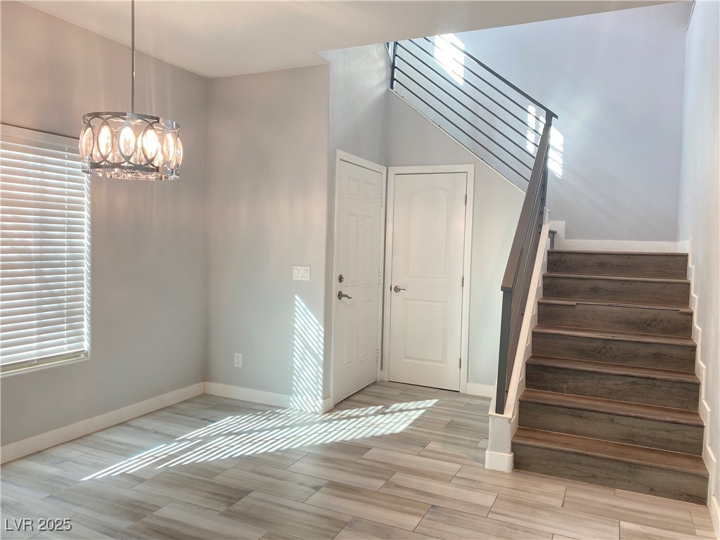 9637 Greensburg Avenue Las Vegas, NV 89178 - Photo 15 of 33 Entrance foyer featuring an inviting chandelier, stairs, baseboards, and wood finish floors