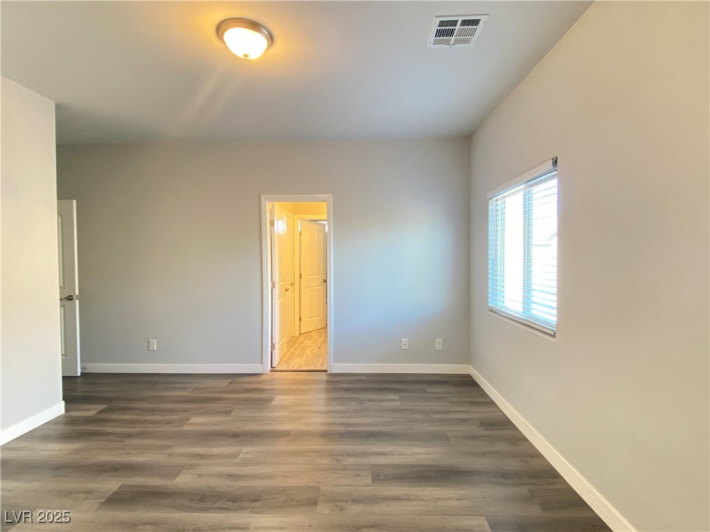 9637 Greensburg Avenue Las Vegas, NV 89178 - Photo 30 of 33 Spare room featuring dark wood-style flooring, visible vents, and baseboards