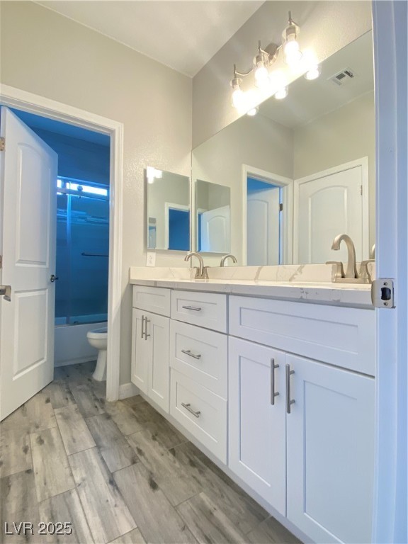 9637 Greensburg Avenue Las Vegas, NV 89178 - Photo 31 of 33 Bathroom with double vanity, visible vents, toilet, a sink, and wood finished floors