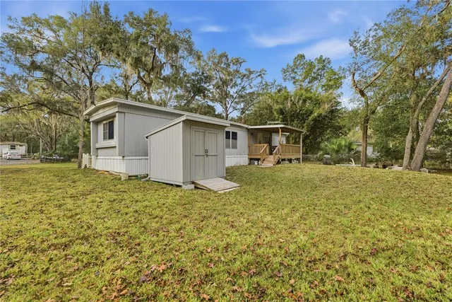 a white house that has tree in front of it
