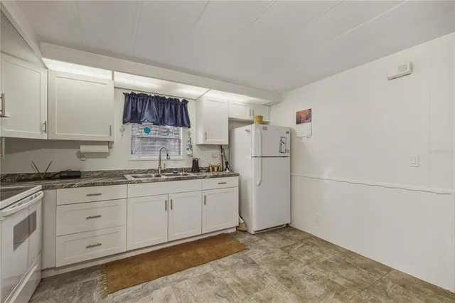 a kitchen with refrigerator and cabinets