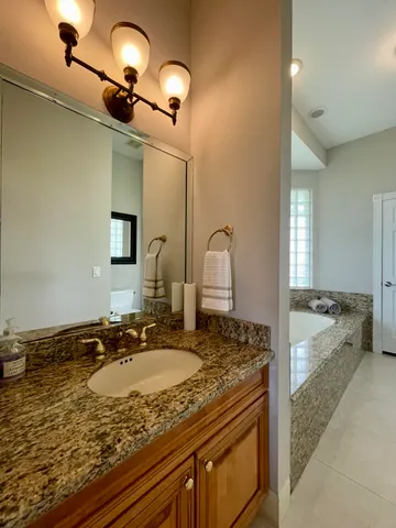 a bathroom with a granite countertop sink and a mirror
