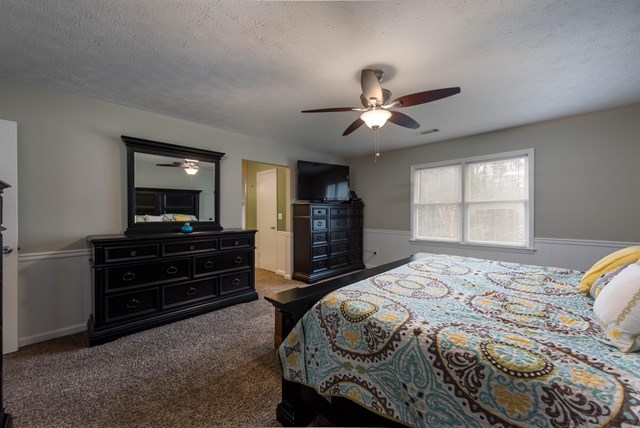 6815 Cartledge Road Box Springs, GA 31801 - Photo 12 of 27 a bedroom with a bed and a dresser