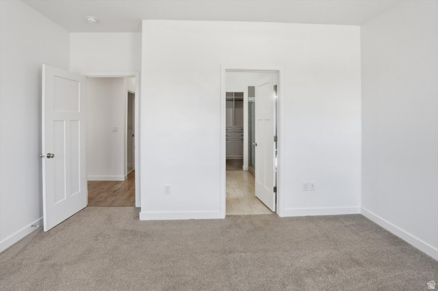 3636 West 910 South Syracuse, UT 84075 - Photo 26 of 70 Neutral carpeted room featuring white walls, white trim, and two paneled interior doors