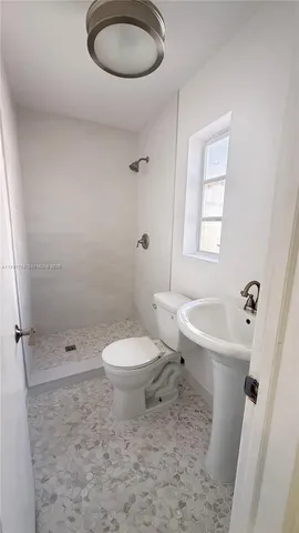 a bathroom with a toilet a sink and a shower