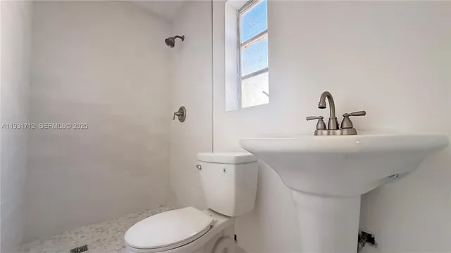 a bathroom with a sink a toilet and a mirror