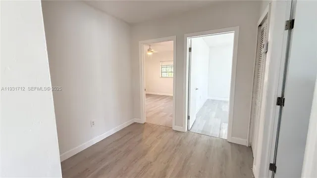 a view of an empty room with wooden floor