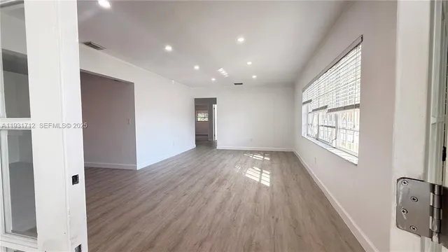 wooden floor in an empty room with a window