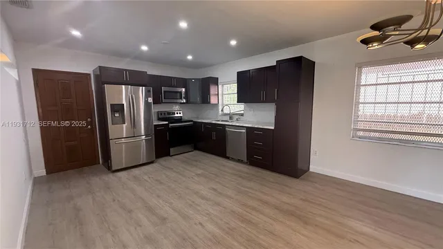 a kitchen with stainless steel appliances granite countertop a refrigerator and a sink