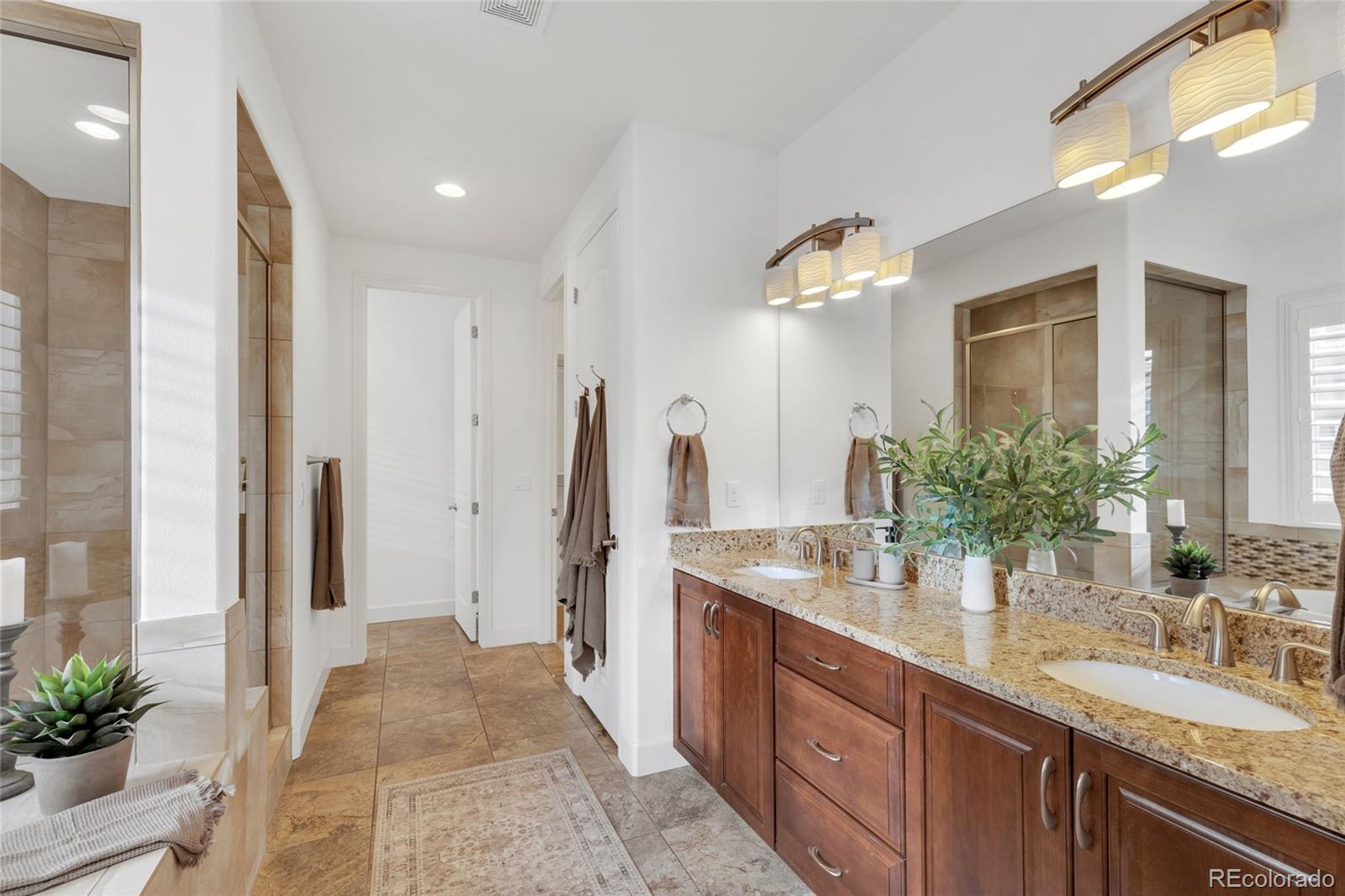 10632 Star Thistle Court Highlands Ranch, CO 80126 - Photo 19 of 50 a spacious bathroom with a double vanity sink and a mirror