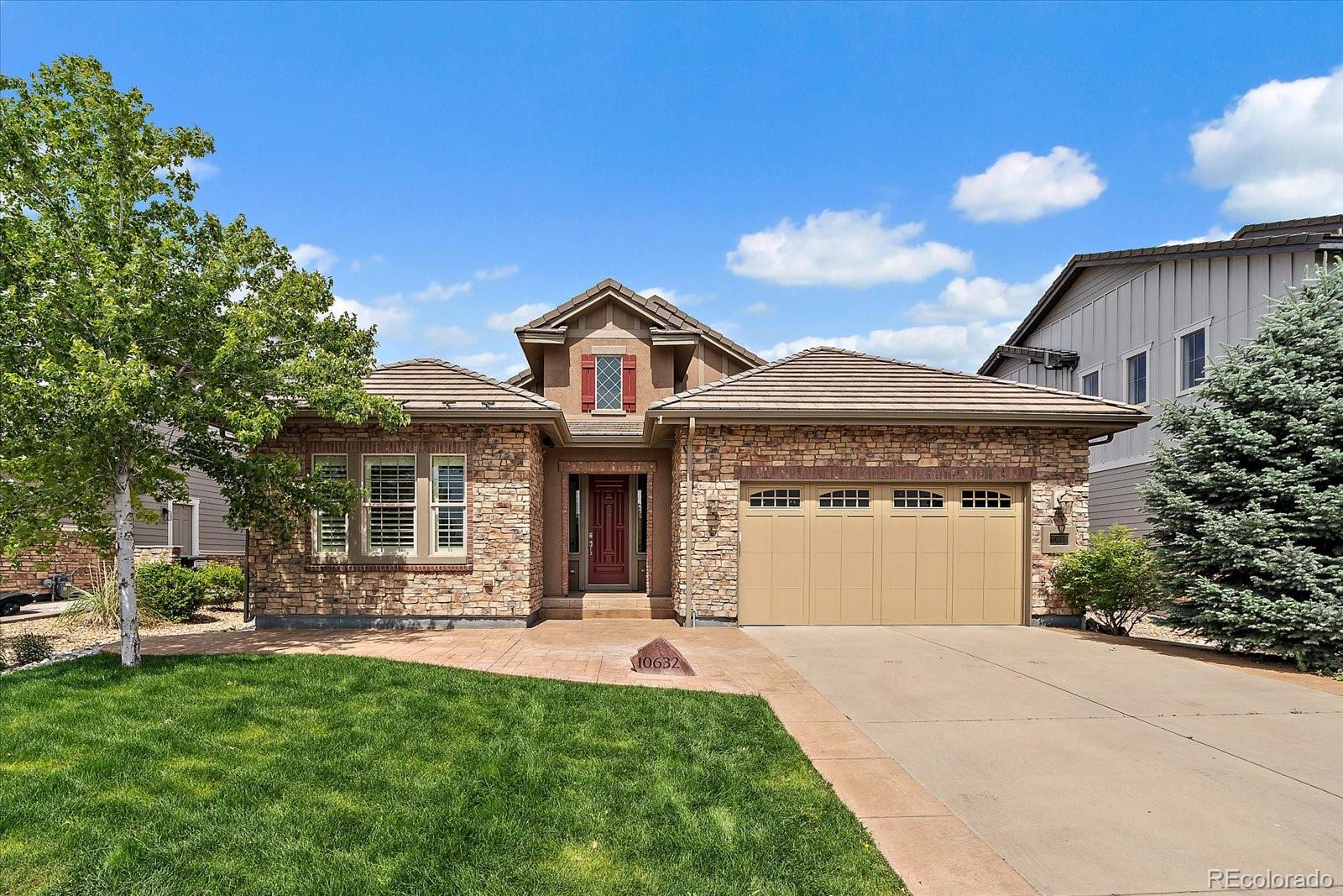 10632 Star Thistle Court Highlands Ranch, CO 80126 - Photo 2 of 50 a front view of a house with a yard and potted plants